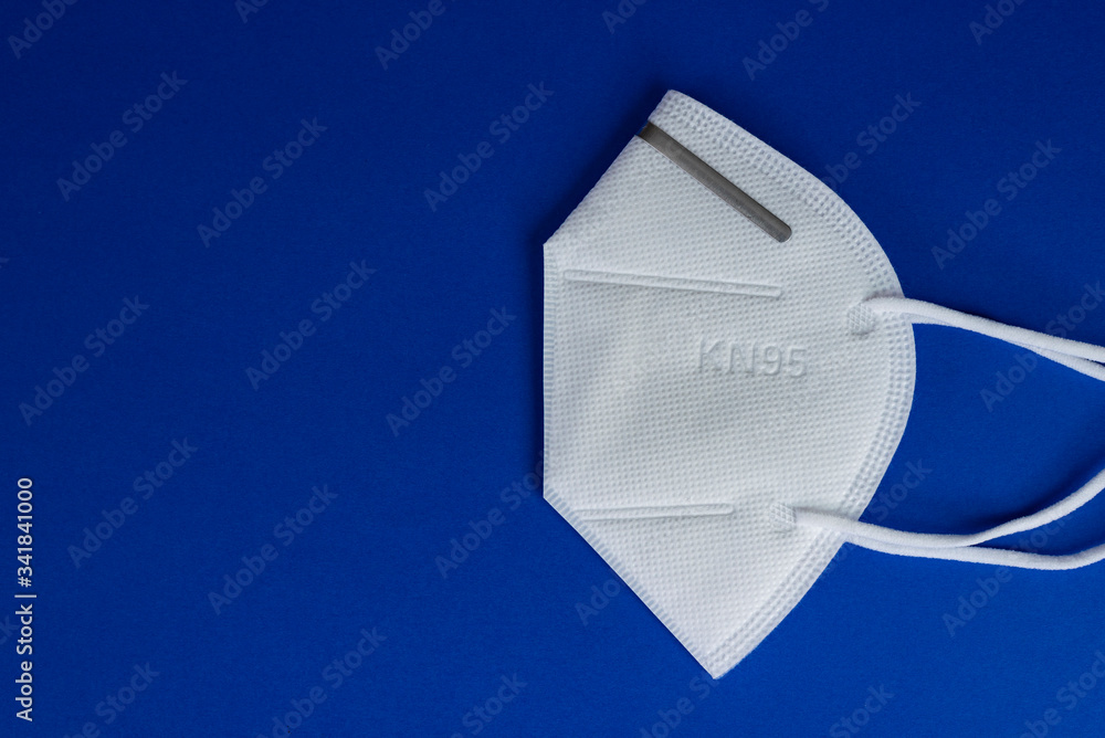KN95 or N95 white mask with antiviral medical mask for protection against coronavirus on blue background. - obrazy, fototapety, plakaty 