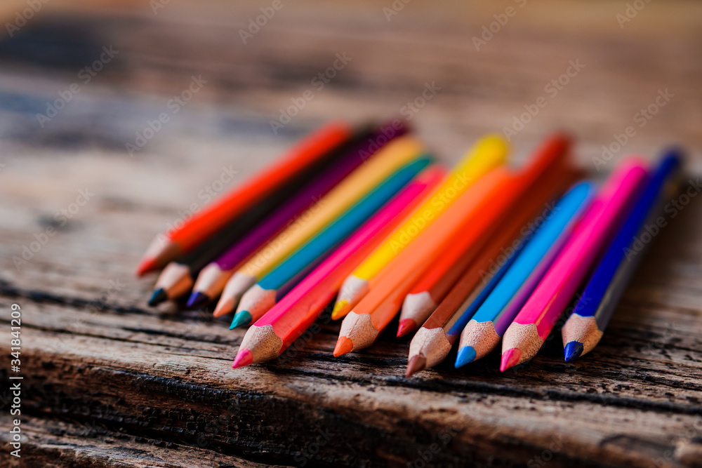 Colored pencils arranged on brown, old rustic wood. The concept of education for children. Back to school or study from home Colored pencils arranged on brown, old rustic wood. The concept of education for children. Back to school or study from home
