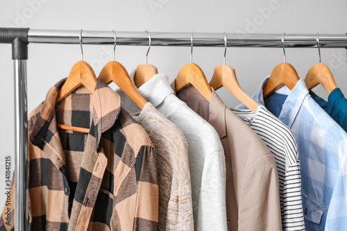 Rack with clothes on light background