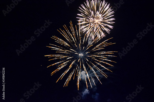 Festive salute in night sky. Explosions of fireworks and pyrotechnics in the sky.