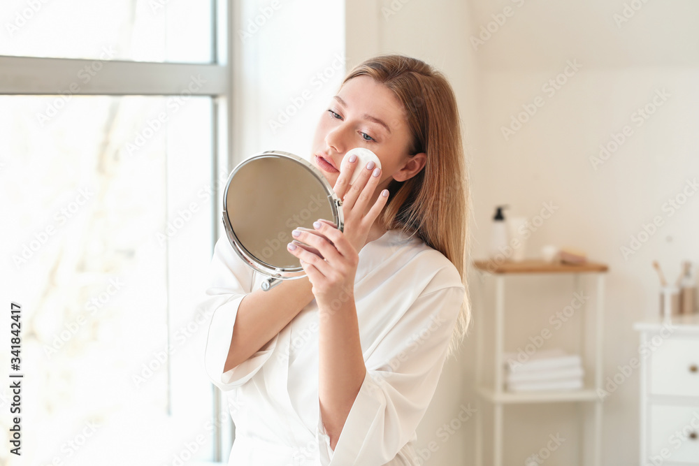 Beautiful young woman removing makeup at home Beautiful young woman removing makeup at home