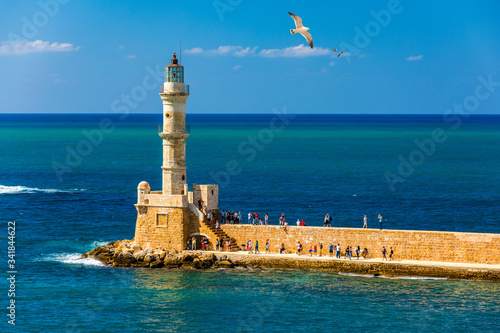 Venetian harbour and lighthouse in old harbour of Chania with seagulls flying over, Crete, Greece. Old venetian lighthouse in Chania, Greece. Lighthouse of the old Venetian port in Chania, Greece. © daliu