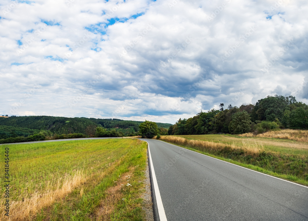 Open Road in future, no cars, auto on asphalt road through green forest, trees, agricultural fields. Green countryside landscape in summer day, Czech Republic, Europe