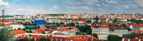 Aerial panoramic cityscape view with old Red Tiles roofs and St Nicholas Cathedral in Old town of Prague city, Czech Republic, Europe. Beautiful summer day, blue sky with clouds at sunset