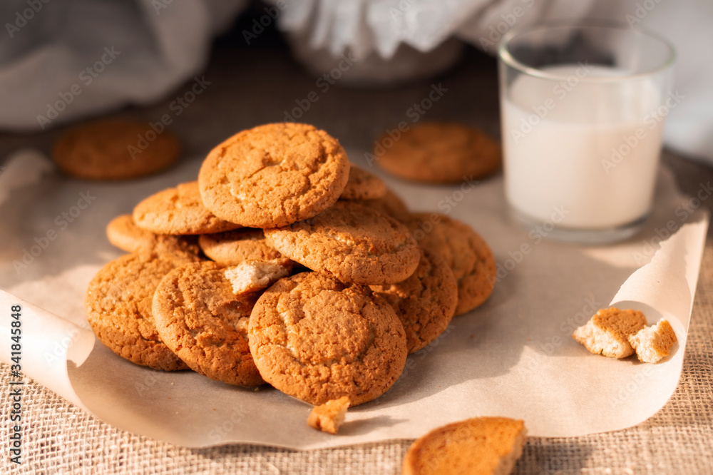 Healthy oatmeal cookies with a glass of milk kids breakfast on burlap fabric background. Homemade food. Eat at home concept Healthy oatmeal cookies with a glass of milk kids breakfast on burlap fabric background. Homemade food. Eat at home concept