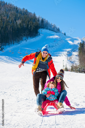 Happy Family In Snow Riding On Sledge.