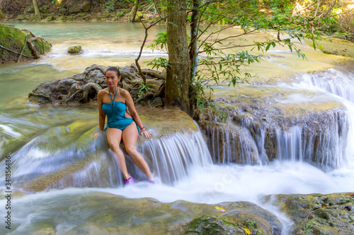 Traveler in blue swimsuit beautiful relax at  Erawan Waterfall