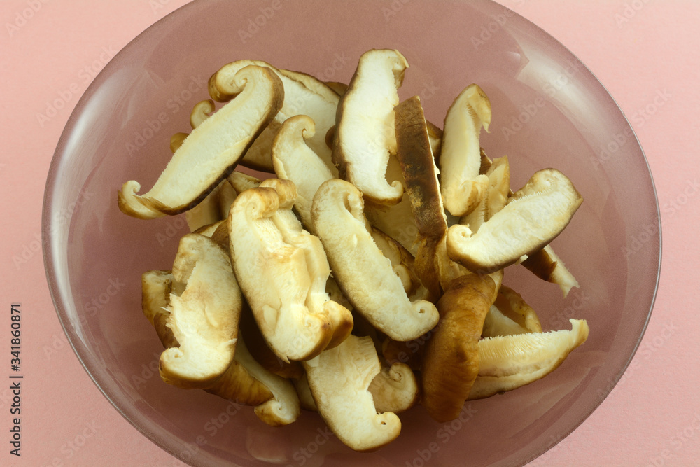 Shitaki mushroom slices in ingredient bowl on pink background for cooking Shitaki mushroom slices in ingredient bowl on pink background for cooking