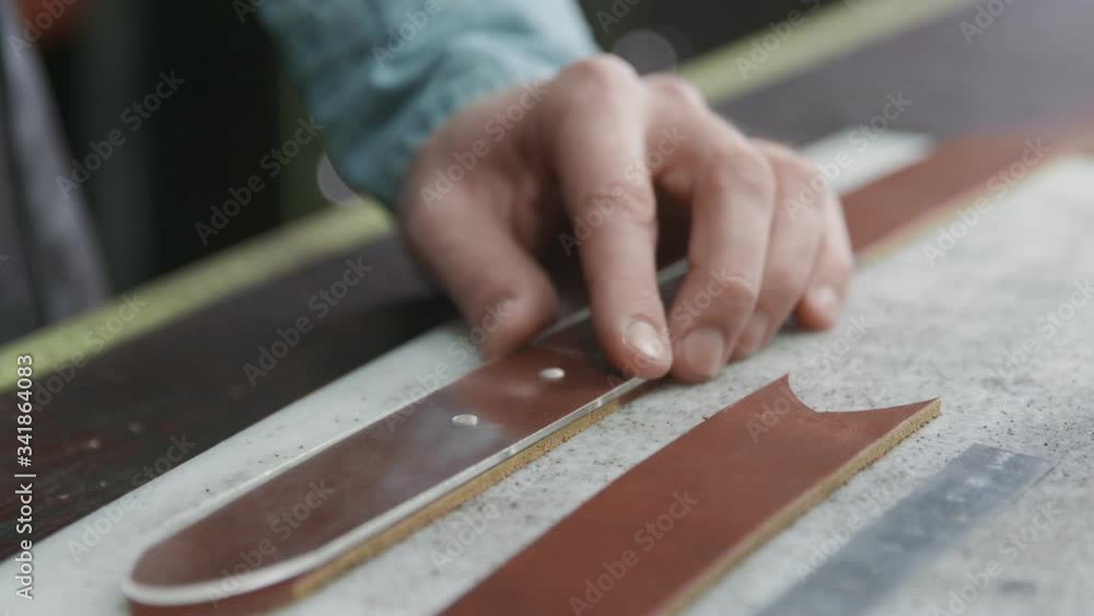 Working process of the leather belt in the leather workshop. Man holding crafting tool and working. Tanner in old tannery. Working process of the leather belt in the leather workshop. Man holding crafting tool and working. Tanner in old tannery.