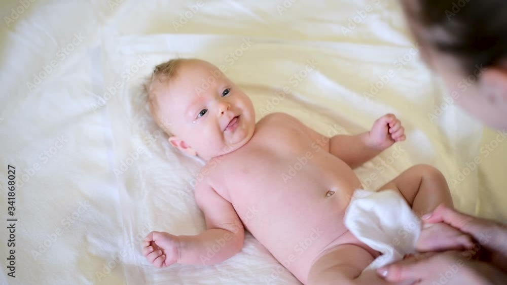 Mom holds baby legs and does exercises with him. Mother playing with cute baby. Mom holds baby legs and does exercises with him. Mother playing with cute baby.