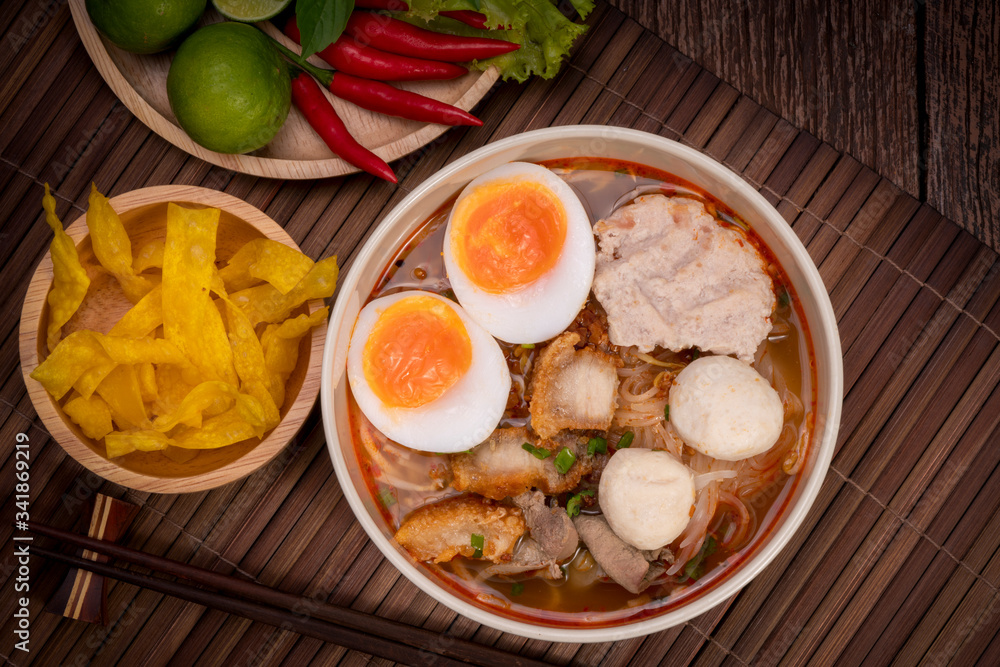 Spicy Noodles with Egg, fish ball and minced pork, Spicy Pork noodle with Spicy soup on wood background. Spicy Noodles with Egg, fish ball and minced pork, Spicy Pork noodle with Spicy soup on wood background.