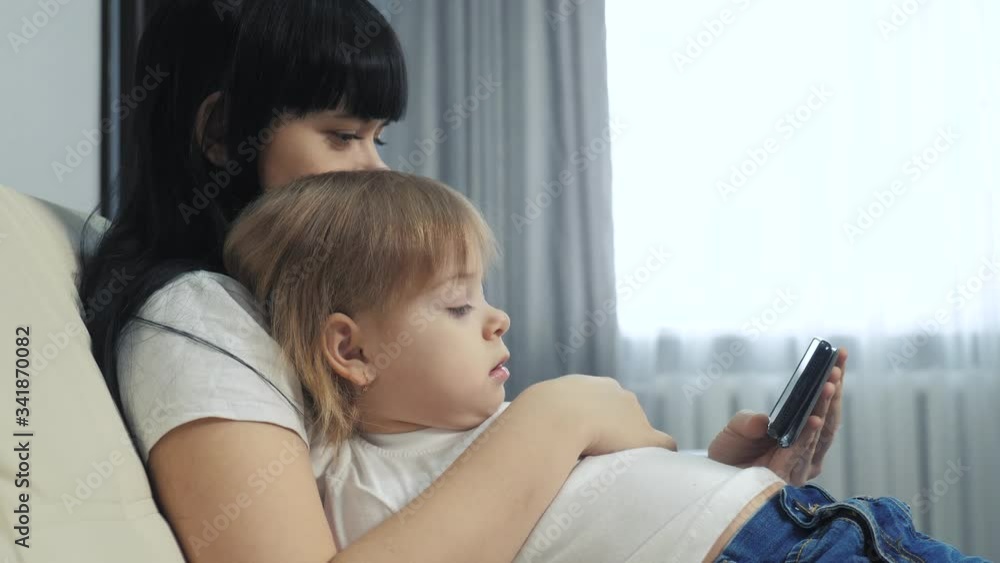 lifestyle girl mom and little kid girl daughter surfs the page online on a smartphone. mother and child daughter watching online shopping at a shopping store lifestyle girl mom and little kid girl daughter surfs the page online on a smartphone. mother and child daughter watching online shopping at a shopping store