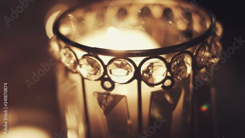 Top view of Burning candle in the metal candlestick decorated with shiny rhinestones, wedding traditional decor elements photo