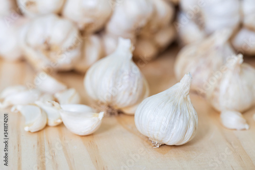 Closeup of Garlic bulb on wooden table with garlics blur background.
