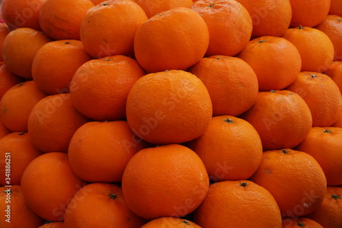 Pile of fresh oranges on market stall.