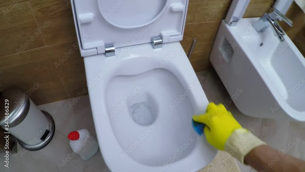POV of man in yellow rubber gloves washing toilet rim with sponge, then flushing water POV of man in yellow rubber gloves washing toilet rim with sponge, then flushing water