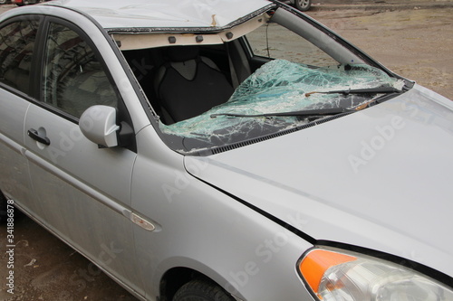 Broken windshield. A broken silver car after an accident on the road. Transport security concept.