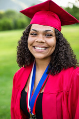 Portrait of a beautiful multi-ethnic woman wearing her graduation cap and gown. Selective focus on her beautiful face
