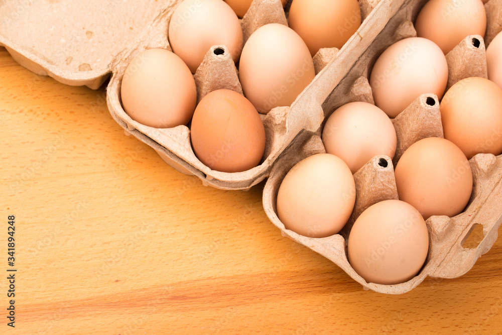brown chicken eggs in an open cardboard box with eggs on a wooden table. Natural healthy food. brown chicken eggs in an open cardboard box with eggs on a wooden table. Natural healthy food.