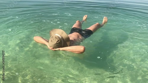 man laying on water, swimming in dead sea jordan