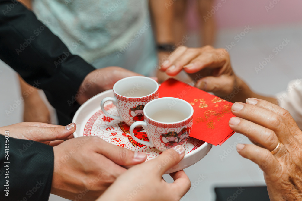 Chinese wedding tea ceremony. Bride and groom serve tea to elders during wedding.