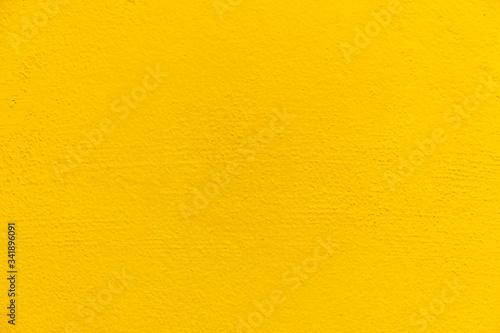 Blurred Yellow stucco wall background. Yellow painted cement wall texture.