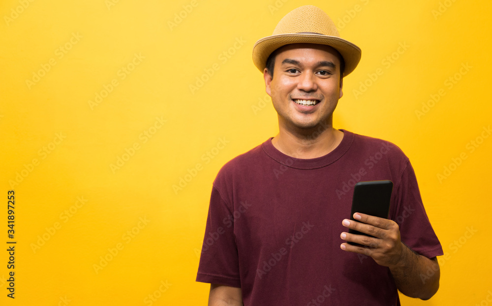 Asian man happy with his smartphone on yellow background. young man using looking at smartphone. Asian man happy with his smartphone on yellow background. young man using looking at smartphone.
