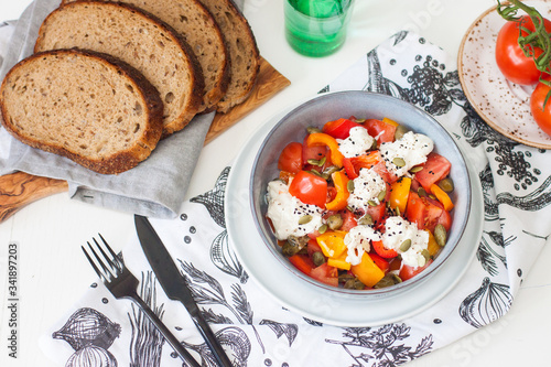 Fototapeta Naklejka Na Ścianę i Meble -  Healthy salad with grilled pepper, tomatoes, stracciatella, herbs and pumpkin seeds. Healthy eating concept.