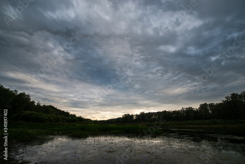 calm river-Ural flows in the sunset and stormy sky