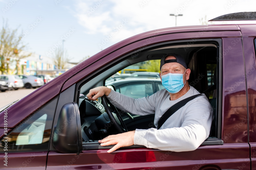 A man in a protective mask driving a car. Portrait of a man in a car in a surgical mask. A man goes to rest in the countryside. A man in a protective mask driving a car. Portrait of a man in a car in a surgical mask. A man goes to rest in the countryside.