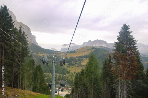 View from the cable car cabin to the village in the mountains and the Dolomites in Italy. Selective focus.
