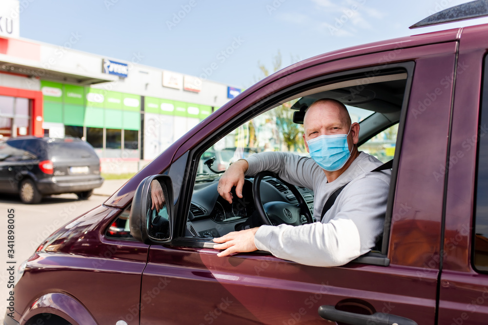 A man in a protective mask driving a car. Portrait of a man in a car in a surgical mask. A man goes to rest in the countryside. A man in a protective mask driving a car. Portrait of a man in a car in a surgical mask. A man goes to rest in the countryside.