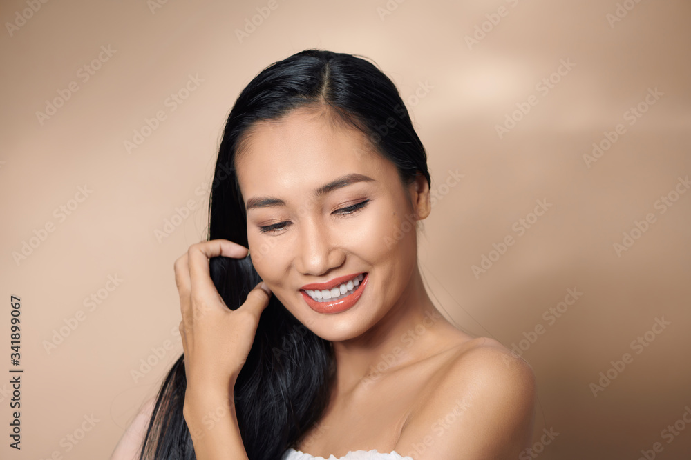 Beautiful sexy asian woman model posing on beige background Beautiful sexy asian woman model posing on beige background