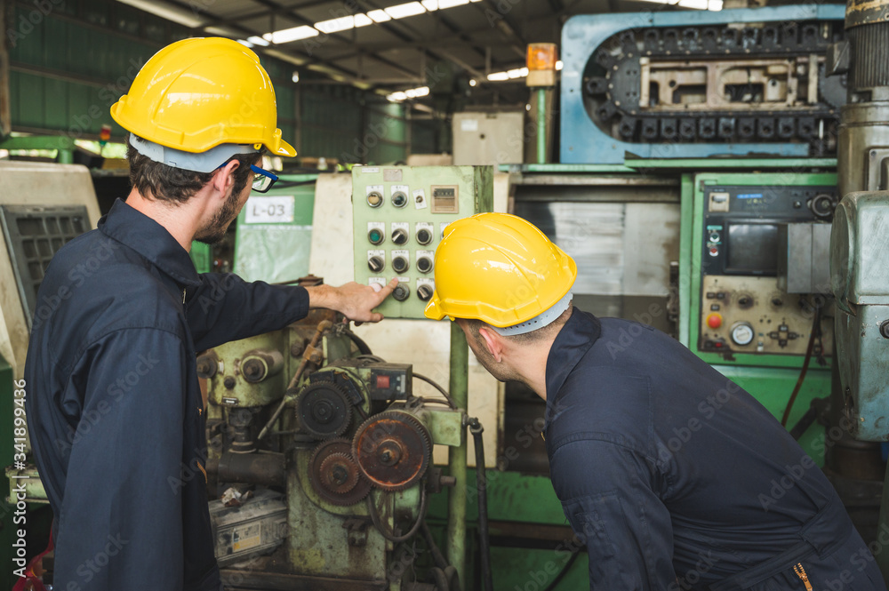 Industrial workers are working on projects in large industrial plants with many devices.