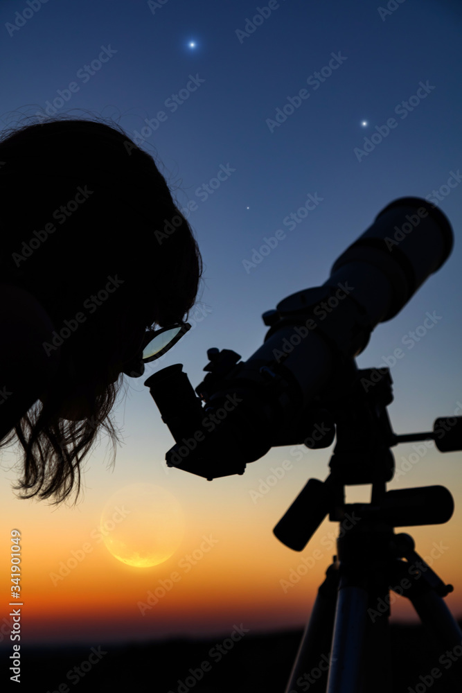 Fototapeta premium Silhouette of a woman and telescope with twilight sky.