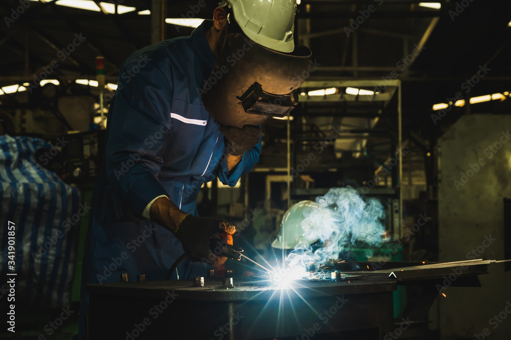 Industrial worker welding metal with many sharp sparks Industrial worker welding metal with many sharp sparks