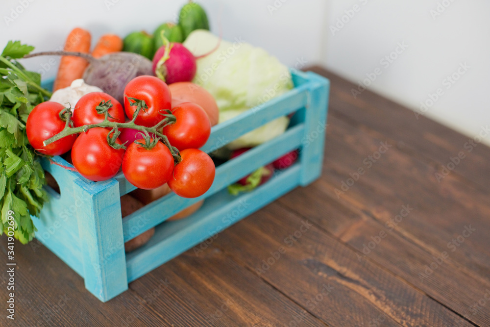 Fresh vegetables in a blue wooden box. Food delivery Fresh vegetables in a blue wooden box. Food delivery