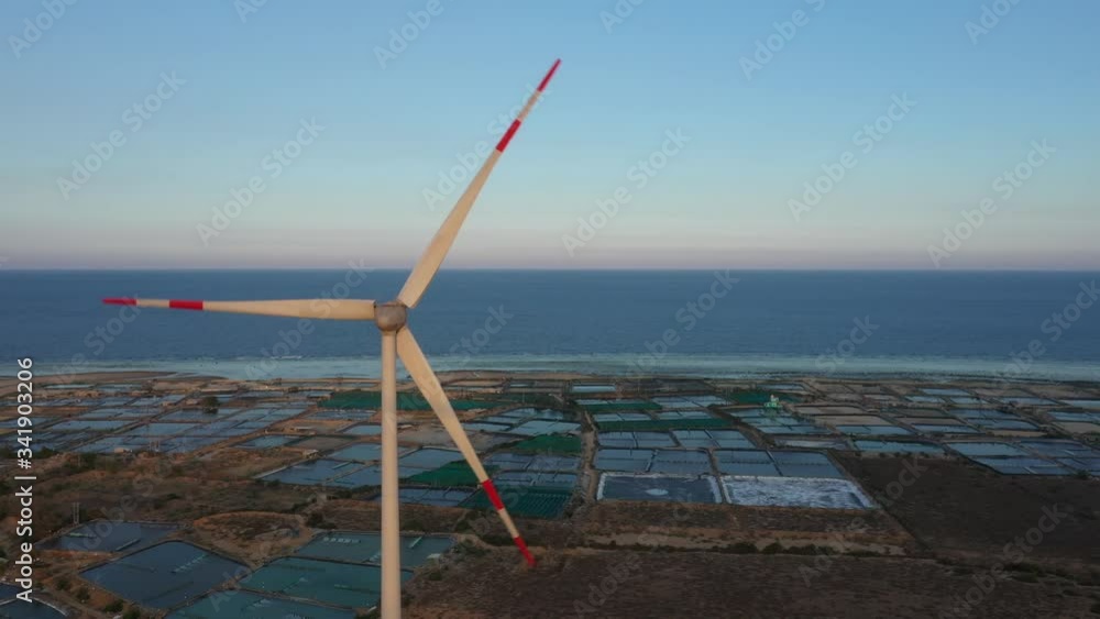 Aerial view of windmills farm for energy production on rice field, Mui Dinh, Ninh Thuan, Vietnam. Wind power turbines generating clean renewable energy for sustainable development Aerial view of windmills farm for energy production on rice field, Mui Dinh, Ninh Thuan, Vietnam. Wind power turbines generating clean renewable energy for sustainable development
