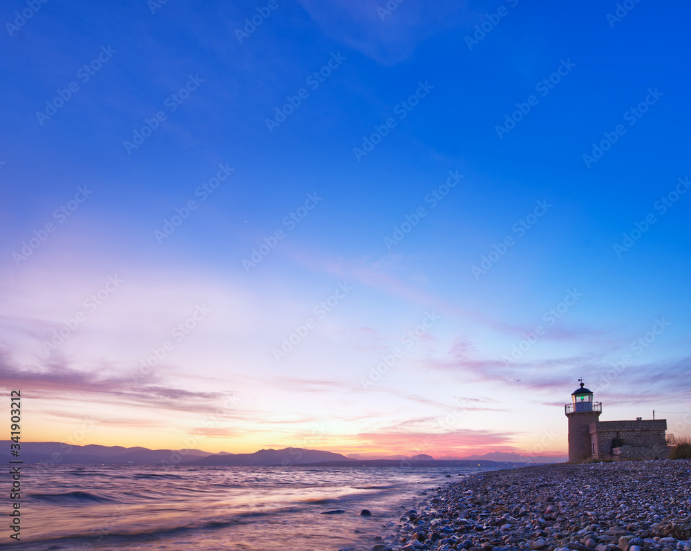 Seaside lighthouse, beautiful sunset, blue sky background, copy space