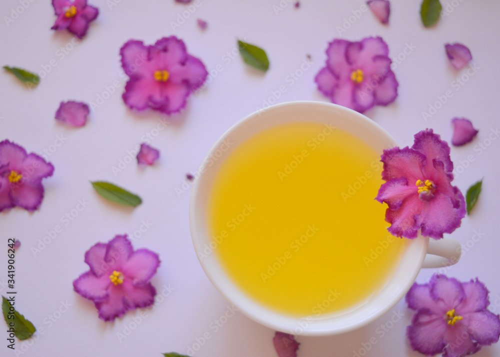 Gourmet concept. Elegant spring (summer) drink.Сup of tea with flowers .Аromatic hot drink. Healthy lifestyle. herbal tea.Top view Gourmet concept. Elegant spring (summer) drink.Сup of tea with flowers .Аromatic hot drink. Healthy lifestyle. herbal tea.Top view