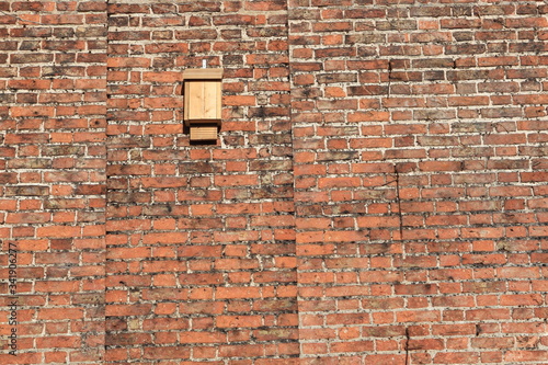 Bat box on an old red  brick wall specifically designed to provide shelter for roosting bats