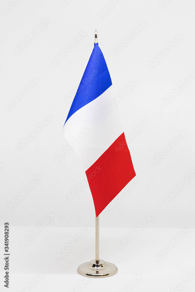 State desktop flag of France on metal flagpole isolated on white background. National symbol State desktop flag of France on metal flagpole isolated on white background. National symbol