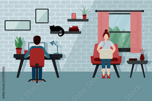 Girl in red headphones and guy with a laptops works from home. Girl on a red armchair and her boyfriend at the work table. Quarantine. Stay at home. Freelancer. Couple in isolation in the flat