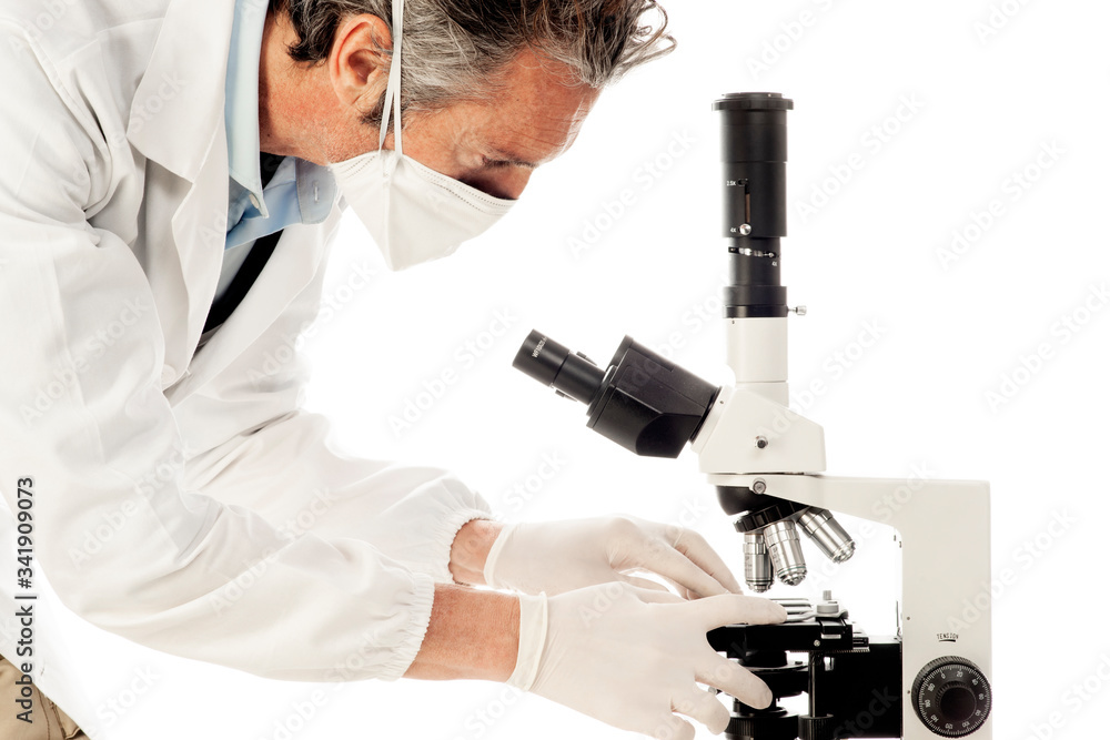 A doctor with mask and gloves working at the microscope A doctor with mask and gloves working at the microscope