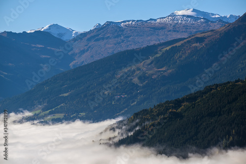 Peaceful misty autumn morning mountain view from hiking path near Dorfgastein, Austria.