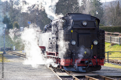 An old steam engine on a trip with lots of steam
