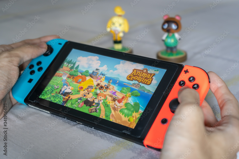 Bangkok, Thailand - March 21, 2020 : A man playing Animal Crossing on Nintendo Switch.