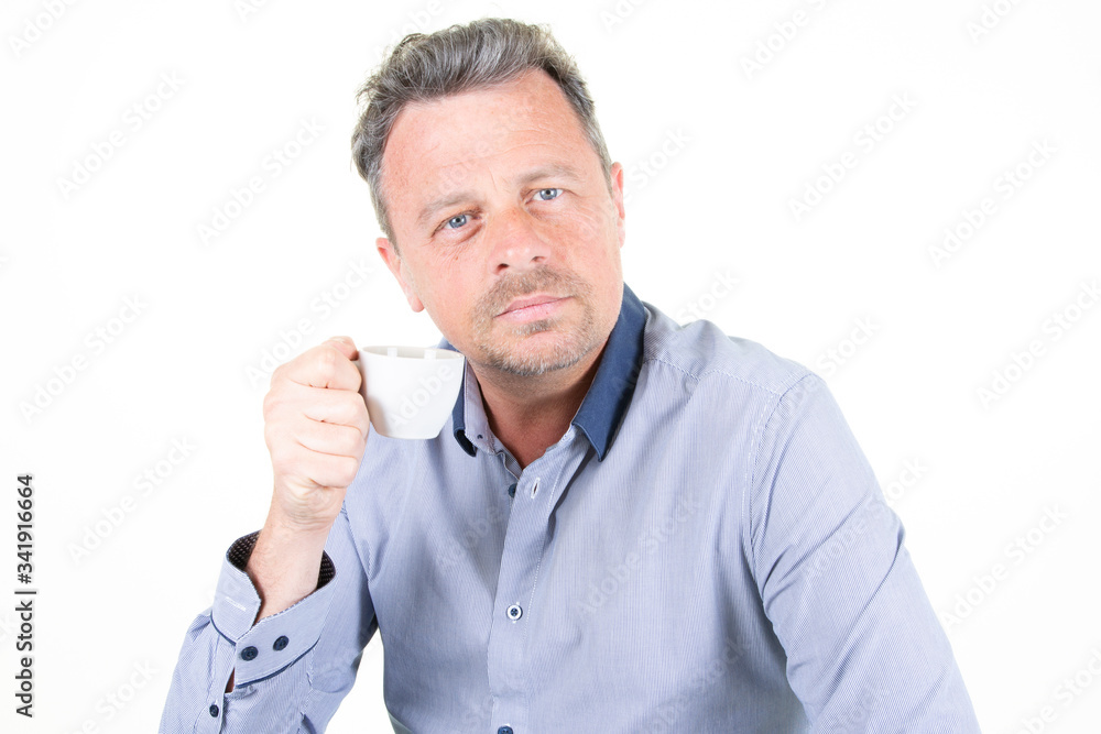 serious businessman handsome man wearing blue shirt drinking coffee from cup isolated over white background serious businessman handsome man wearing blue shirt drinking coffee from cup isolated over white background