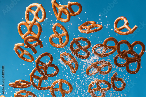 salty pretzel flies with salt on a blue backgroun photo