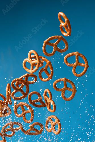 salty pretzel flies with salt on a blue backgroun